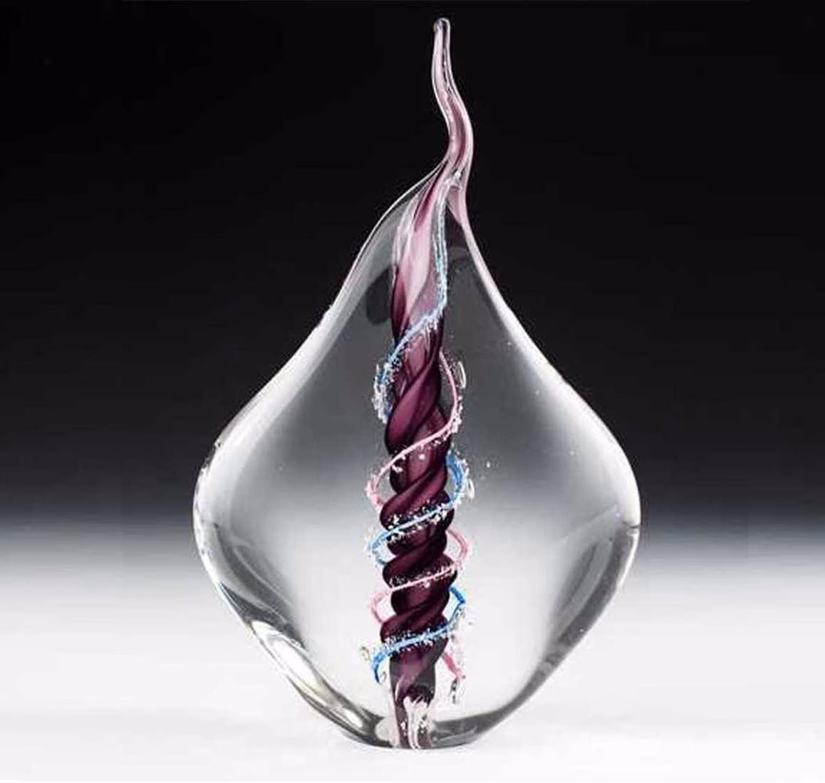 Dual flame glass memorial sculpture with cremation ash, featuring a clear teardrop form encasing intertwined purple, blue, and pink glass flames symbolizing eternal connection and remembrance.