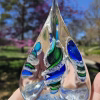 Handmade glass pyramid memorial with cremation ash in aqua, blue, and green.