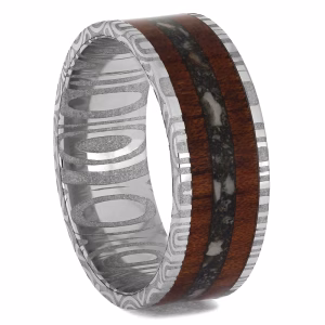 Cremation ring with ashes featuring bloodwood inlay and damascus steel sleeve memorial band, angled interior view