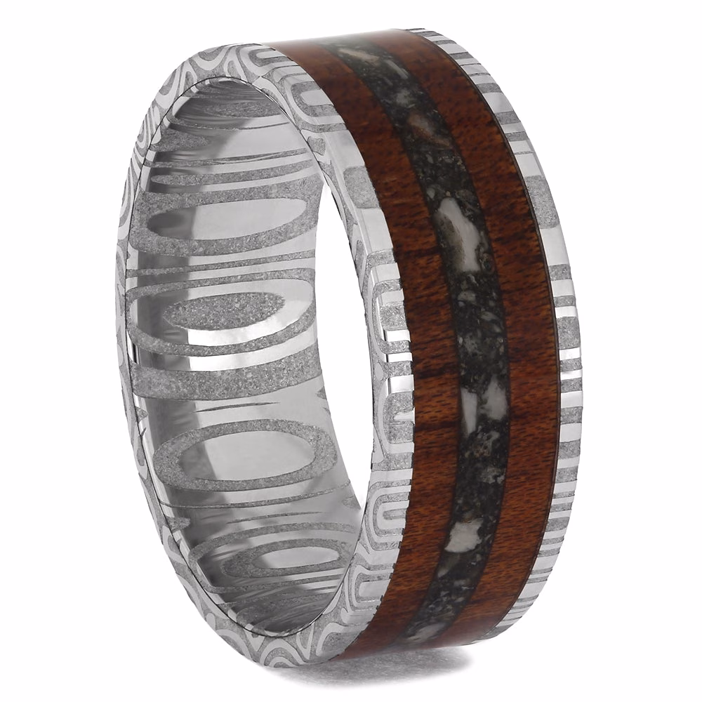 Cremation ring with ashes featuring bloodwood inlay and damascus steel sleeve memorial band, angled interior view