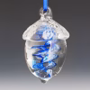 Hand-blown glass acorn memorial ornament featuring a clear acorn shape with a vibrant blue swirling spiral infused with cremation ash, suspended from a blue ribbon against a soft gradient background.