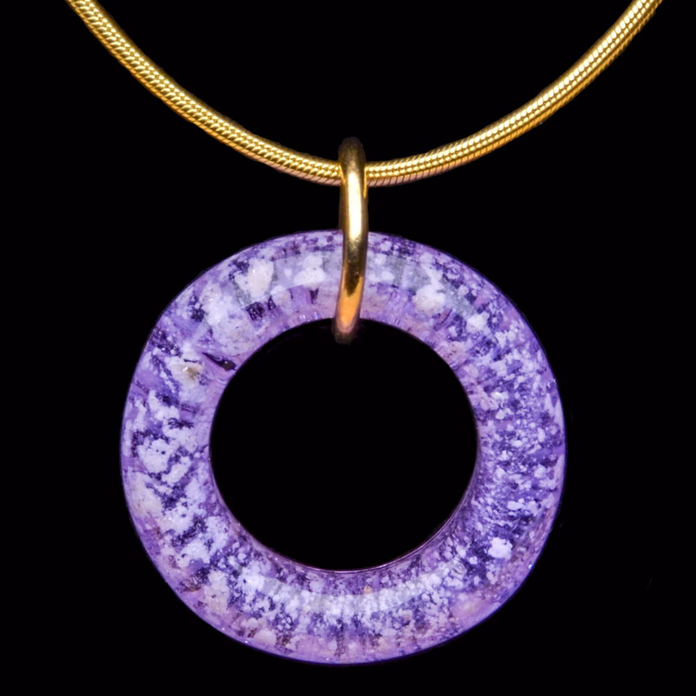 Amethyst halo cremation pendant with encased cremation ash on gold necklace displayed on black background