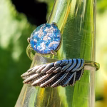 Angel Wing Cremation Ring with blue and teal memorial glass made from cremation ash in a sterling silver wing band