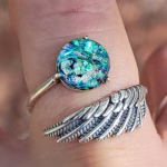 Angel Wing Cremation Ring with blue and teal memorial glass made from cremation ash in a sterling silver wing band