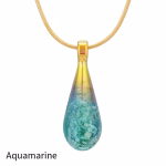 Teardrop cremation pendant in Aquamarine glass with cremation ash encased inside, shown on a gold-tone chain.