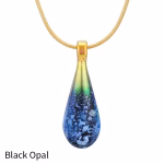 Teardrop cremation pendant in Black Opal glass with cremation ash encased inside, shown on a gold-tone chain.