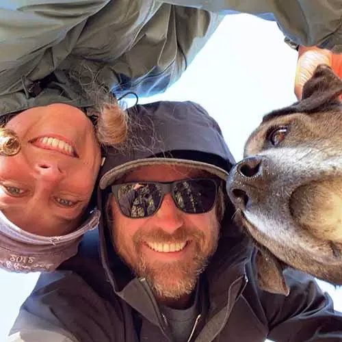 Portrait of Sands of Time artist Bryan R. outdoors with a companion and a dog, smiling at the camera.