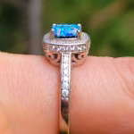 Side view of the Cremation Ring with Square Halo Band, showing the raised blue silver crinkle glass center stone secured by prongs, with cubic zirconia accent stones along the halo and down the silver band.