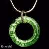 Halo Cremation Pendant in emerald green, featuring a rich green glass ring with lighter ash inclusions, suspended from a silver chain against a black background.
