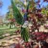 Handmade green glass hummingbird with translucent wings and cremation ash encased in the body.