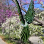 Handmade green glass hummingbird made with cremation ash.