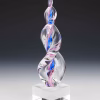 Hand-blown glass Legacy Flame cremation sculpture featuring swirling pink and blue ribbons encased in clear glass, set on a polished square glass base, created as a vibrant and meaningful memorial keepsake.