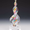 Aqua, pink, and gold Legacy Flame cremation ash sculpture featuring swirling multicolor ribbons encased in clear hand-blown glass, displayed on a polished square glass base as an elegant memorial keepsake.