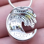 Back view of the Ocean Wave Cremation Pendant showing the sterling silver construction, S925 stamp, and open wave design with perforated backing behind the blue memorial glass inlay.