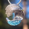 Ocean Wave Cremation Pendant in sterling silver featuring blue memorial glass beneath a sculpted wave design.