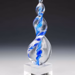 Blue Legacy Flame cremation ash sculpture featuring a hand-blown twisting clear-glass flame with vivid blue swirls, crafted as a memorial art glass keepsake and displayed on a polished glass base.