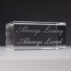 Close-up of a clear crystal display base engraved with the inscription “Always Loving, Always Loved”.