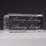 Close-up of a clear crystal display base engraved with the inscription “Always Loving, Always Loved”.