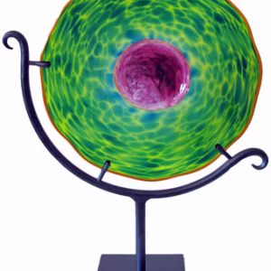 Radiance memorial glass suncatcher with cremation ash displayed on a black metal stand, featuring a translucent green rippled glass disc with a purple center and circular organic texture.