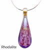 Teardrop cremation pendant with rhodalite purple glass, encased cremation ash, displayed on a silver chain against a white background