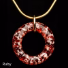Halo Cremation Pendant in ruby red glass, suspended from a gold-toned chain against a black background.