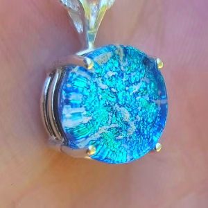 Close-up of a sterling silver halo cremation pendant with blue silver crinkle glass.