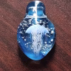 Handcrafted glass jellyfish cremation pendant featuring a detailed white jellyfish suspended in vibrant blue glass with swirling white flecks of encased cremation ashes, shown in a full top-down view to highlight shape, color, and clarity