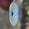 Side view of Boho Flower cremation pendant with iridescent glass memorial stone in sterling silver.