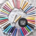 Dezaree resin color chart showing assorted mica powder colors in clear vials arranged in a circular layout on a white background