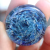 Round Galaxy cremation stone made with memorial glass featuring swirling blue tones