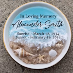 Oceanside Ring Dish with Cremation Ash in a round ceramic dish featuring ocean waves, sandy shoreline, seashells, a starfish, and personalized memorial text with name and dates