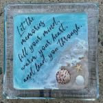 Oceanside Ring Dish with Cremation Ash in a square glass dish featuring ocean waves, sandy shoreline, seashells, a starfish, and a handwritten memorial quote in black script
