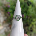 Memorial heart cremation ring featuring a heart-shaped setting with cremation ash suspended in green resin on a silver band