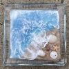 Oceanside Ring Dish with Cremation Ash, handcrafted square glass ring dish featuring an ocean wave design with blue and white glass, sandy shoreline details, and embedded seashells and starfish