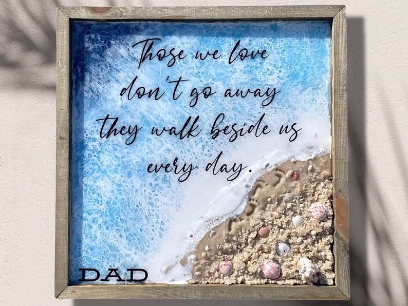 Square Oceanside Memorial made with cremation ash, featuring a tranquil shoreline scene with ocean waves, textured sand, seashells, and a memorial quote honoring a loved one’s enduring presence.