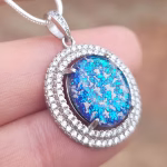 Halo Cremation Pendant with Cubic Zirconia in sterling silver, featuring a blue memorial ash inlay shown on a silver chain