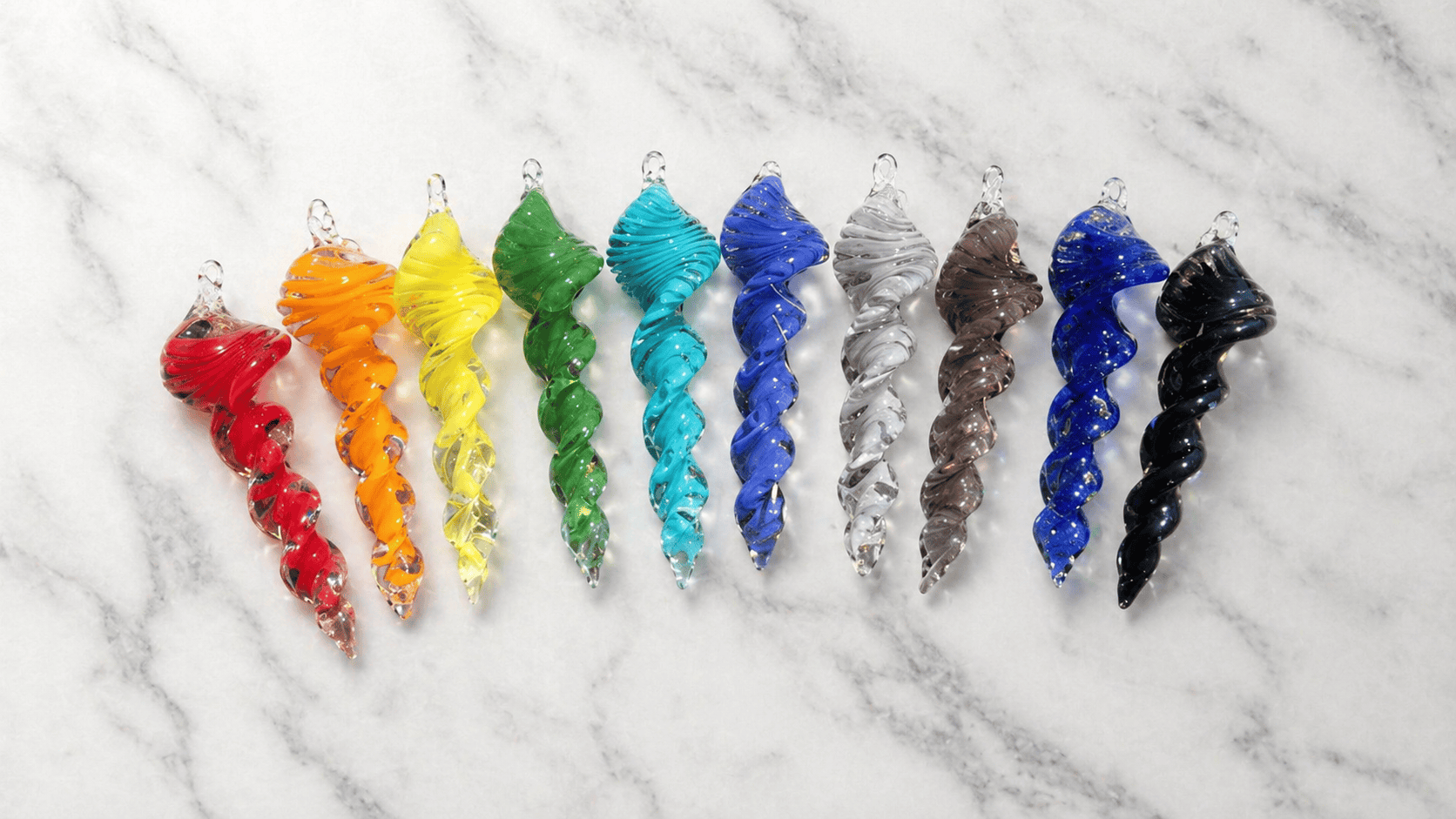 Colorful cremation art glass spinners with rainbow hues and embedded ashes.
