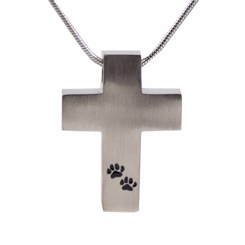Pewter cross cremation necklace featuring two engraved paw prints on the front, designed to hold a small amount of pet ashes as a memorial keepsake