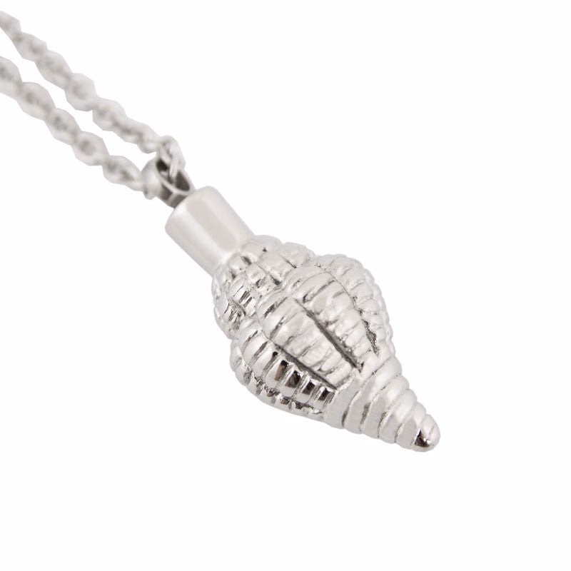 Close-up of a stainless steel seashell cremation pendant with intricate ridged detailing, shown with its threaded screw top removed.