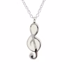Silver treble clef cremation pendant with white enamel inlay hanging from a silver chain.