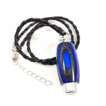 Hearthwood urn cremation pendant shown in royal blue and charcoal laminate wood with silver metal core on braided black cord against white background