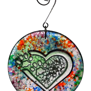 Loving paw print heart glass suncatcher with multicolor splatter design and encased cremation ash, hanging in window on metal hook