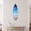 Oceanside surfboard-shaped memorial clock featuring a resin shoreline design with seashells and cremation ash, displayed hanging on a light-colored wall in a coastal-inspired room.