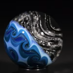 Handmade Shadow Marble with Cremation Ash featuring black glass and blue pinwheel backing
