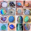 Straight-on front view of a multi-image color chart displaying various memorial glass color options in ring and pendant settings, used to help customers select a color for cremation jewelry designs.