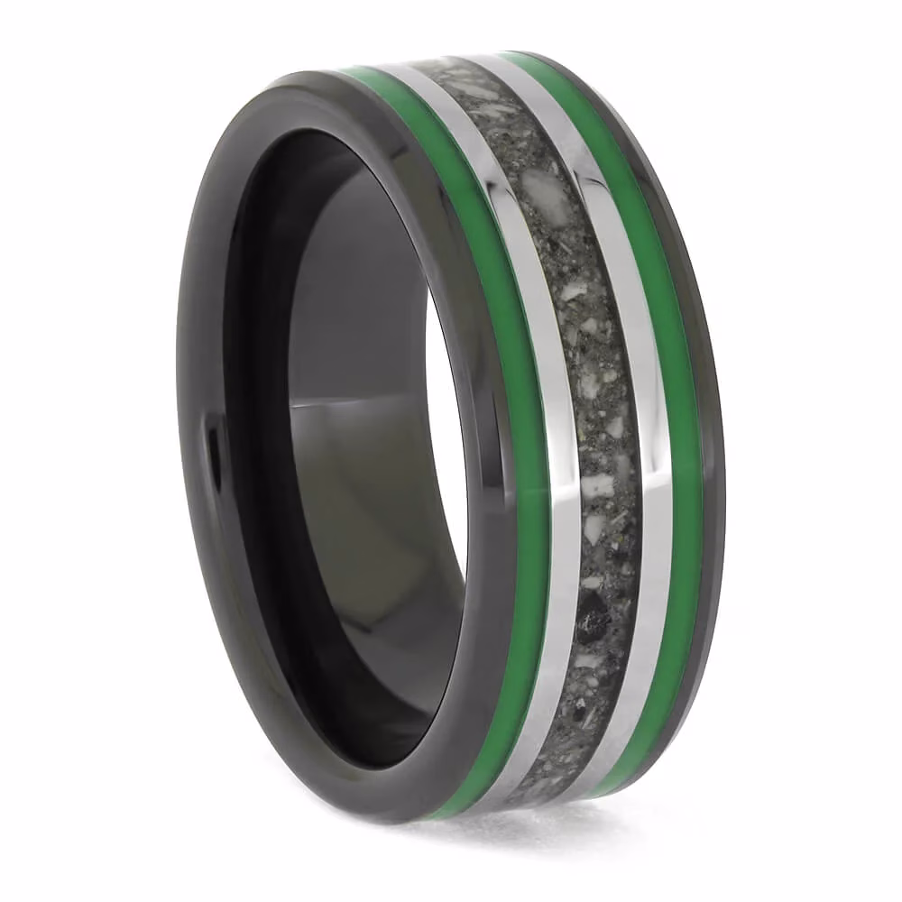 Angled side view of black ceramic memorial ring with green enamel pinstripes and titanium inlay band containing cremation ashes.