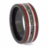 Angled view of black ceramic memorial ring with red enamel pinstripes and titanium inlay band containing cremation ashes.
