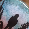 Forest Pines Suncatcher with Cremation Ash close-up showing cremation ash texture blended into the blue and pink sky behind the silhouetted figure and pine trees