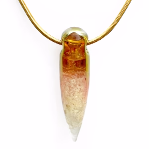 Solid glass crystal cremation pendant with visible cremation ashes inside, featuring a clear-to-amber gradient created with pure gold fume and suspended from a gold snake chain.