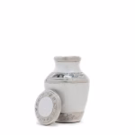 Enamel White Ripple Brass Keepsake Urn with removable lid placed beside the urn on a white background